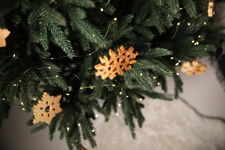 Natural-ash-wood-snowflake-ornament-with-detailed-carving-and-smooth-finish