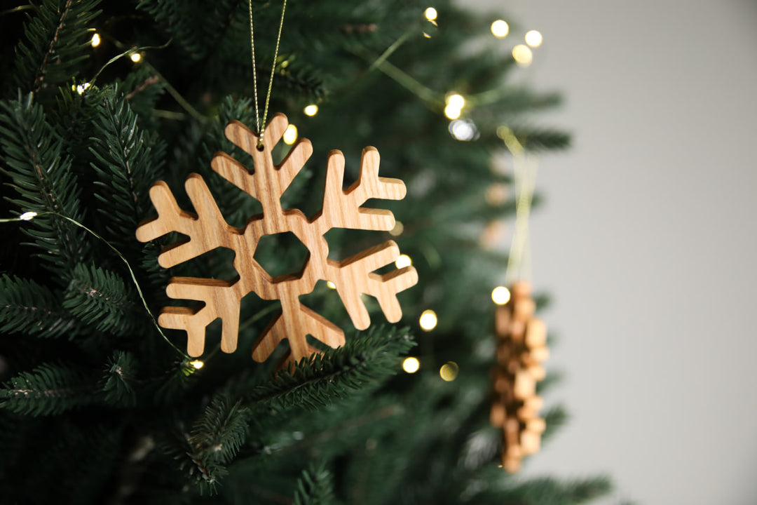 Natural-ash-wood-snowflake-ornament-with-detailed-carving-and-smooth-finish