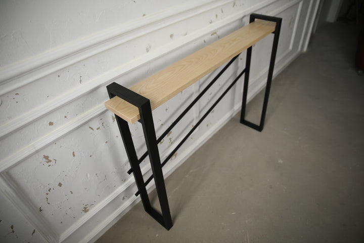 slim-wood-and-metal-console-table-placed-along-a-hallway-wall