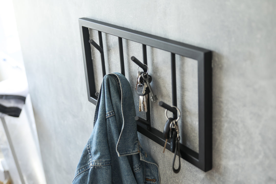 Modern-black-metal-wall-mounted-coat-rack-with-a-minimalist-tree-branch-design-Perfect-for-organizing-coats-hats-and-accessories-in-a-stylish-way
