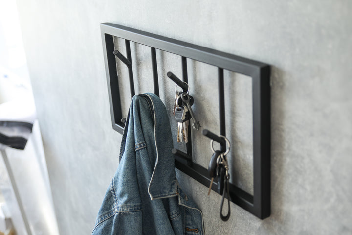 Modern-black-metal-wall-mounted-coat-rack-with-a-minimalist-tree-branch-design-Perfect-for-organizing-coats-hats-and-accessories-in-a-stylish-way