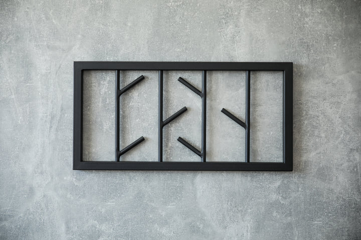Modern-black-metal-wall-mounted-coat-rack-with-a-minimalist-tree-branch-design-Perfect-for-organizing-coats-hats-and-accessories-in-a-stylish-way
